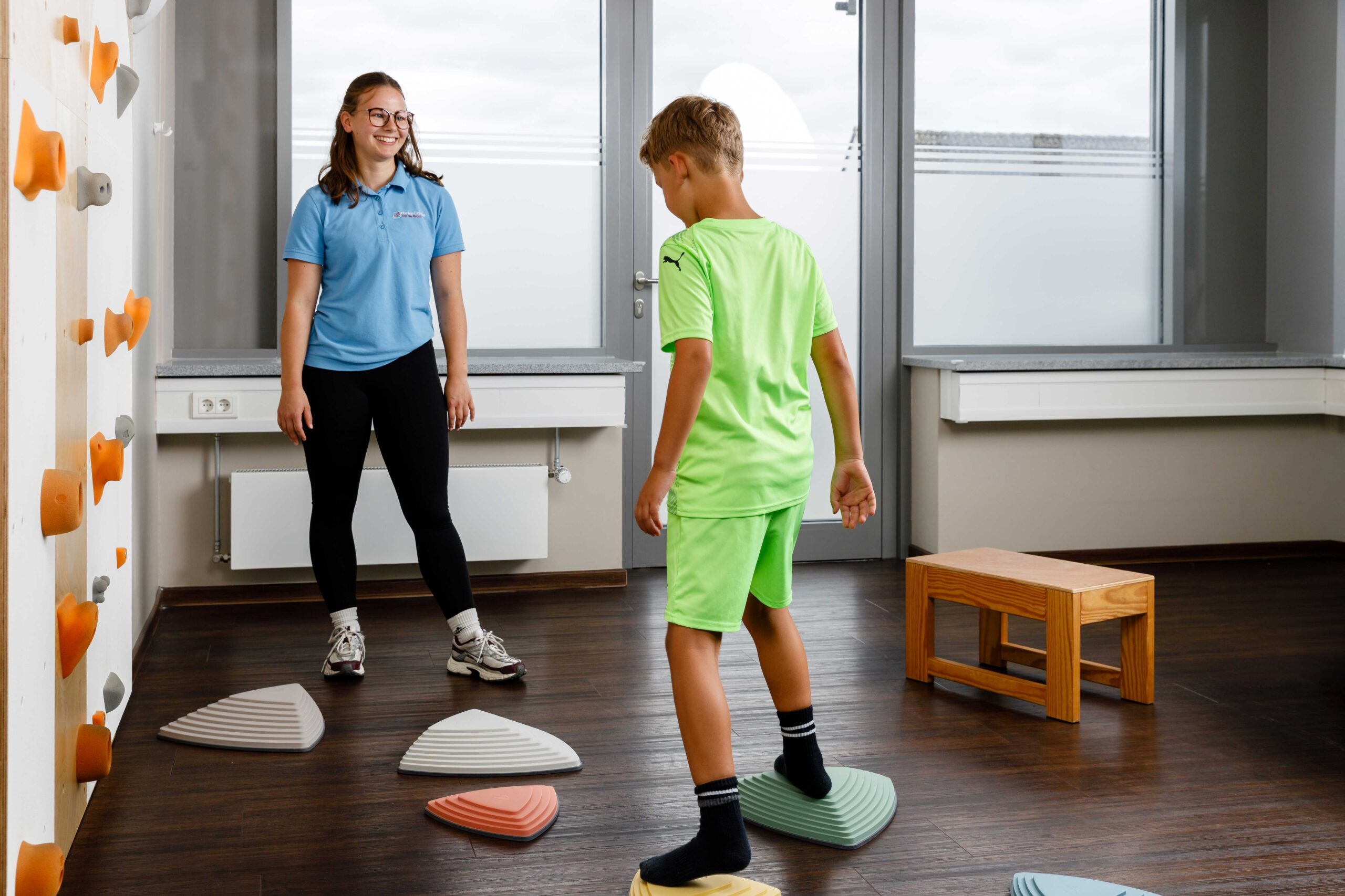 Physiotherapeutin_mit_Junge_auf_Balanciersteinen